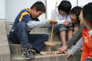 表紙写真：子ども考古学教室で火起こし体験（賀露小学校）