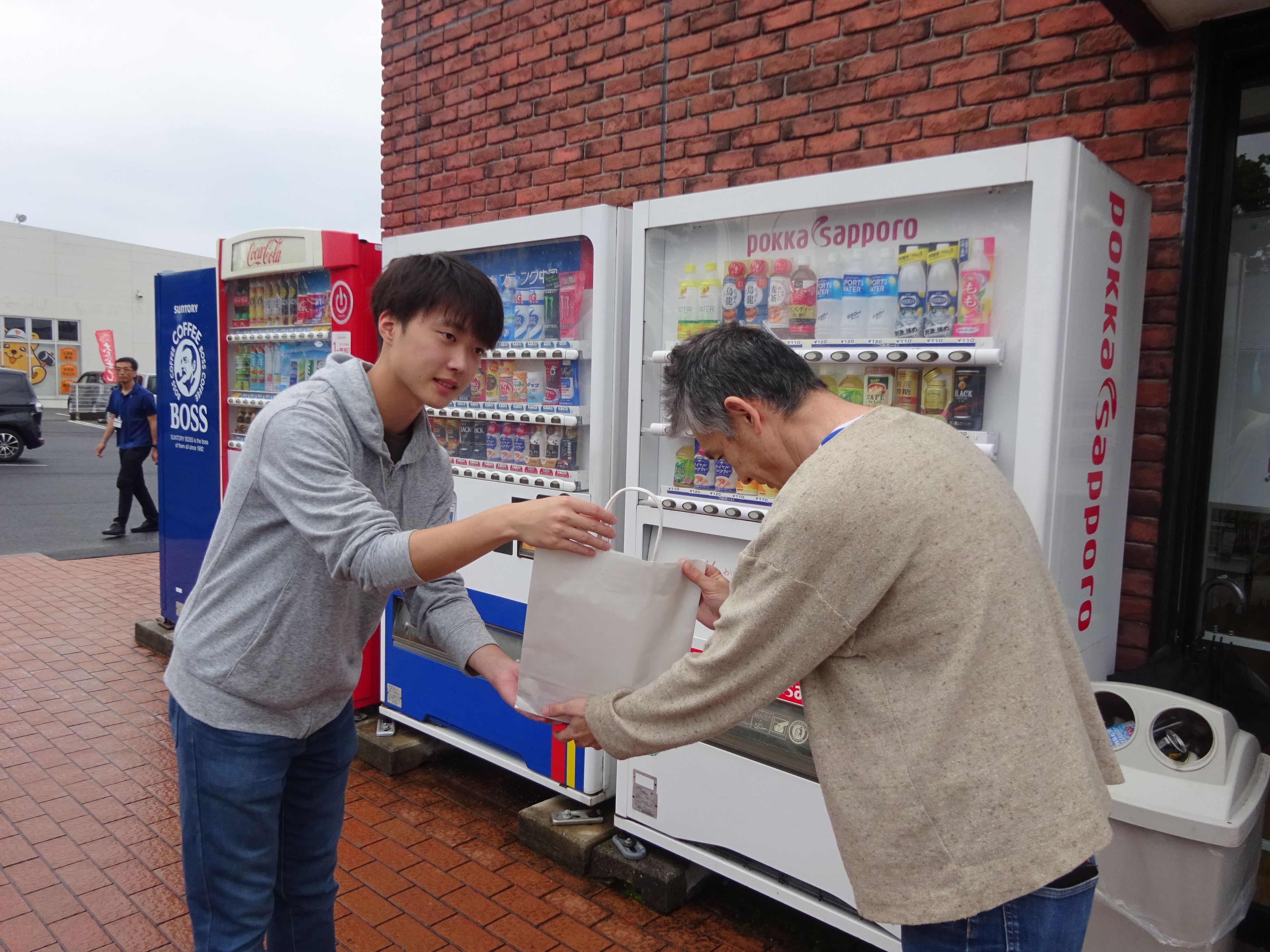 釣り客に啓発物品を配布する公立環境大学の生徒達